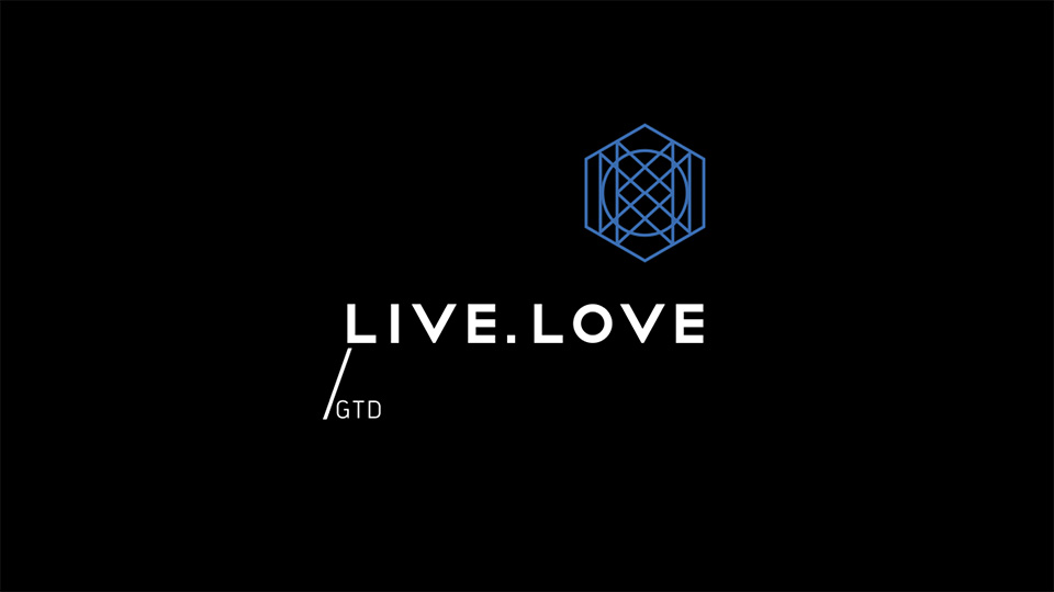 Лінійний логотип LIVE.LOVE GTD: білий текст та синій гексагональний елемент з ліній на темному фоні