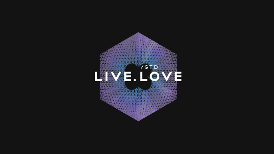Логотип LIVE.LOVE GTD (білий текст, фіолетово-блакитний гексагон) на темному тлі для сайту